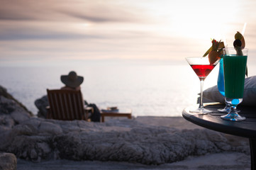 girl on beach having sunset cocktail