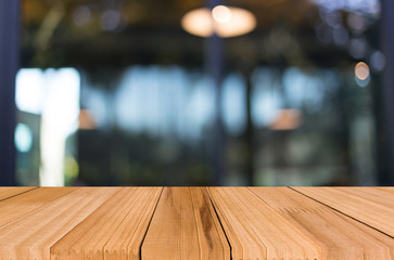 Selected focus empty brown wooden table and Coffee shop blur bac