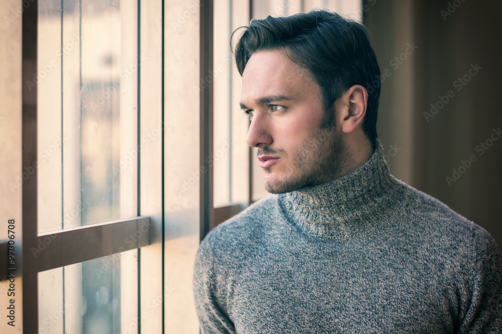 Wall mural handsome serious man standing inside modern building