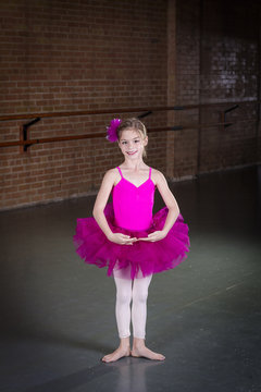 Beautiful little dancer portrait at a dance studio. Vertical photo in a traditional dance studio. Lots of copy space above