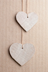 Couple of cardboard cutted hearts against striped cardboard sheet