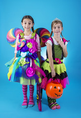 Cute little girls in Halloween costumes ready to go trick or treating