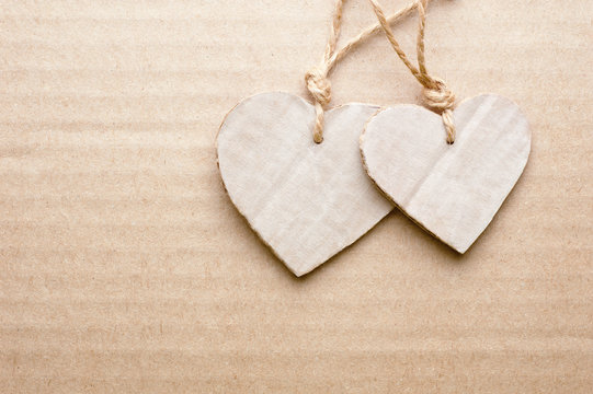 Couple of cardboard cutted hearts against striped cardboard sheet