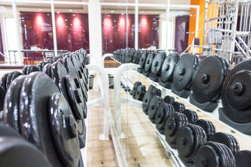 Black dumbbell in fitness center room for background