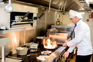 Chef preparing  cuisine in hotel kitchen