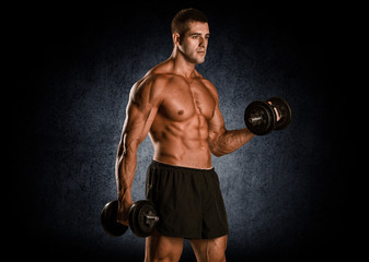 Obraz na płótnie Canvas Closeup of a muscular young man lifting weights