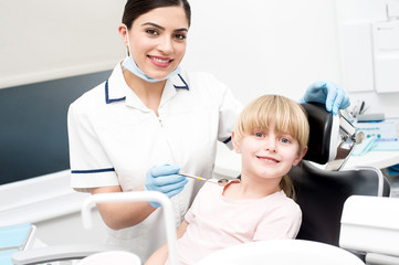 Professional dentist posing with girl child