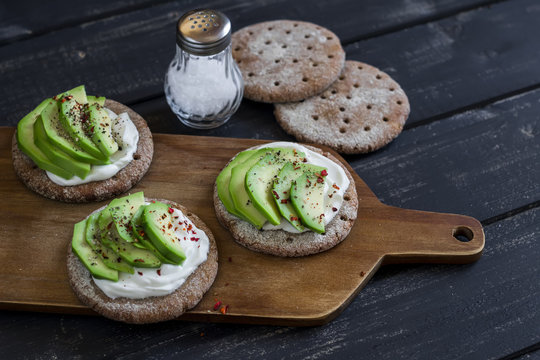 Healthy avocado sandwiches, served on the board on a dark wooden surface. Healthy breakfast or snack