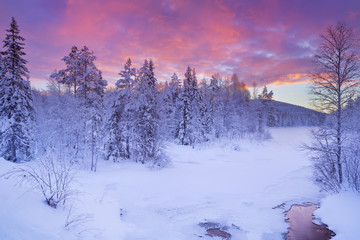 Sunrise over a river in winter near Levi, Finnish Lapland