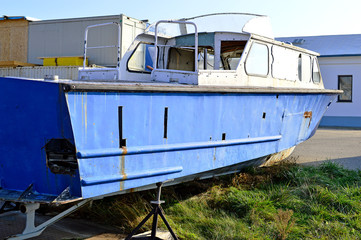 Fototapeta na wymiar Aufgebocktes desolates Motorboot
