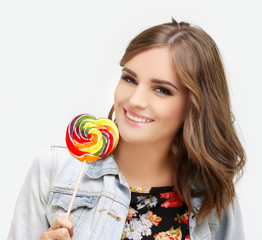 Laughing girl holding big lollipop.Blue background.