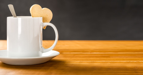 Kaffeebecher mit einem herzförmigen Keks