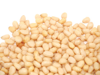 Peeled pine nuts on a white background