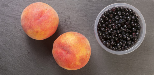 fresh peaches and blueberries on dark background