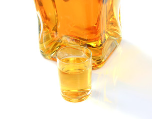 Bottle and small glass with amber liquid