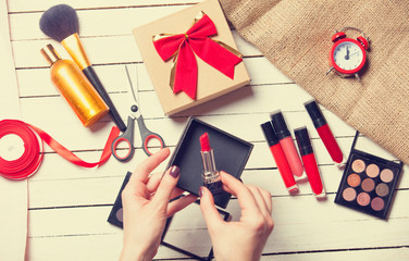 hands are wrapping cosmetics in christmas gifts