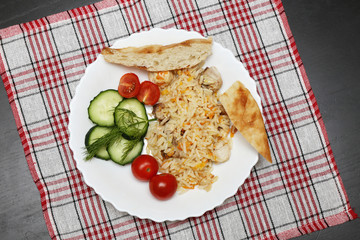 pilaf with chicken pita bread and vegetables on the plate