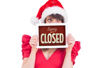 Composite image of festive brunette holding a tablet pc