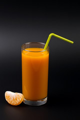 Fruits and juice of tangerine on a black background