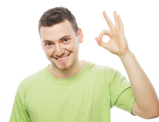 Fototapeta premium young man in green shirt showing thumbs up. 