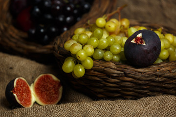 Still life of bunch of grapes,figs and plums