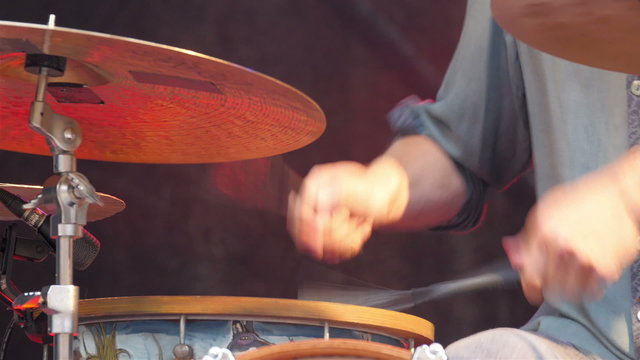 Fast playing of the drumsticks with strips on the tip. The dummer is enjoying his performance during the concert