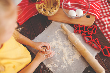 Happy little child baking Christmas cookies at home