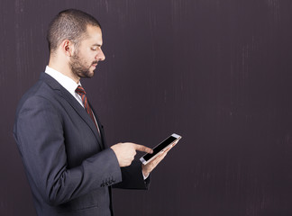 Young male executive using a digital tablet against grunge backg