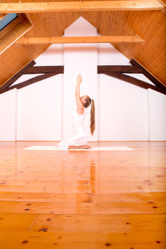 Woman practicing Yoga in a Studio..