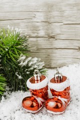 Fototapeta na wymiar zwei Weihnachtsstiefel im Schnee mit Tannenzweig im Hintergrund 