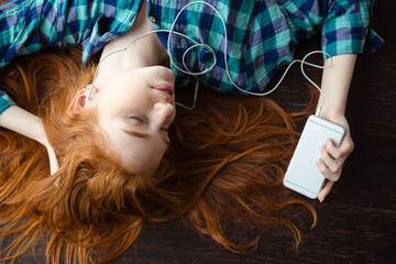 Woman lying on floor and listening to music