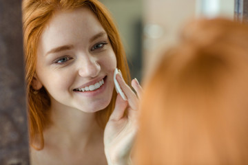 Woman with wadding looking at her reflection in mirror