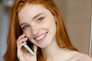 Woman talking on the phone and looking at camera