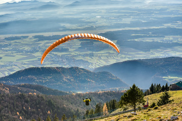 Paraglider is flying in the valley - obrazy, fototapety, plakaty