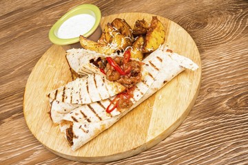  Pancakes with meat and sauce on wooden table.