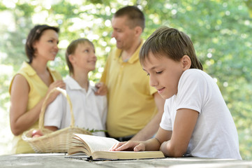  Family with kids and book outdoors