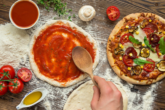 Italian pizza preparation with ingredients around.