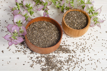 Chia seed healthy super food with flower over white wood backgro