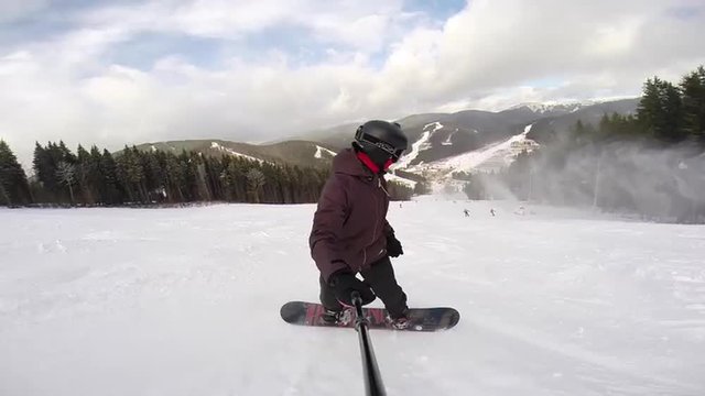 Snowboarder is riding on slope pov