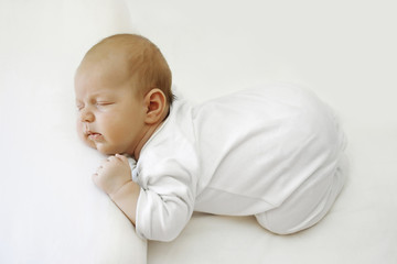 newborn baby sleeping on a white bed