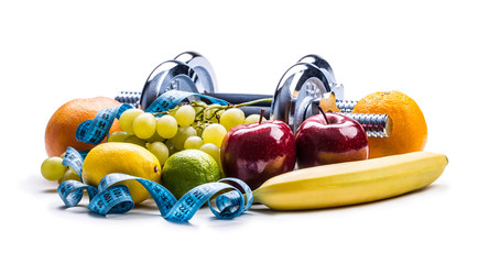 Chrome dumbbells surrounded with healthy fruits measuring tape on a  white background with shadows....
