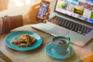 Man working on notebook, with a fresh cup of coffee.