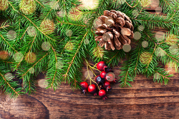 Christmas fir tree with decoration on dark wooden board.