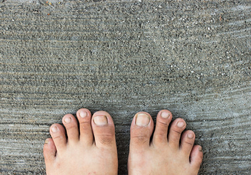 Top View of Bare Foot on Cement Floor Background. Walk to the Na