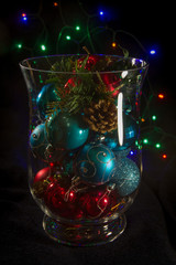 Decorative vase filled with shiny Christmas ornaments.
