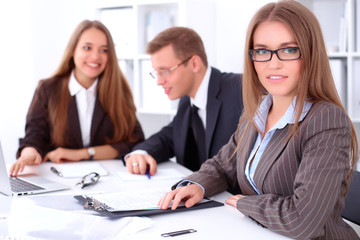 A group of business people at a meeting on the background of office. Focus on a beautiful brunette