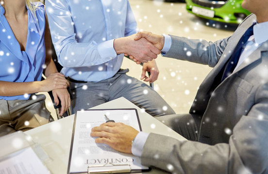 handshake of customer and car dealer in auto salon