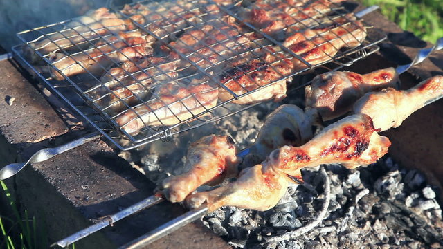 Chicken meat pieces being fried on a charcoal grill at the outdoors