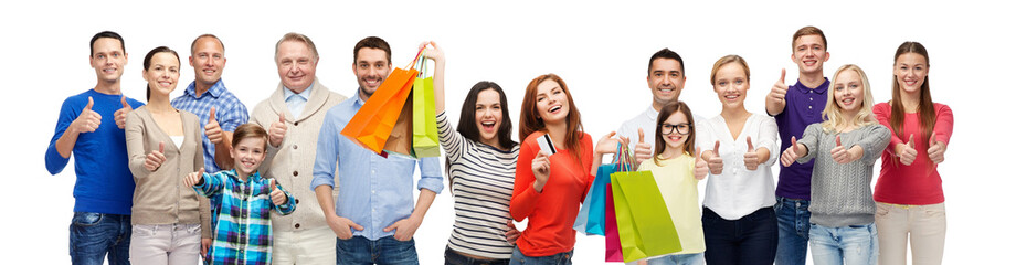 happy people with shopping bags showing thumbs up