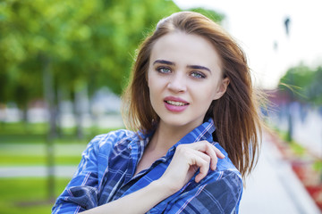 Close up of young beautiful woman in a checkered blue shirt